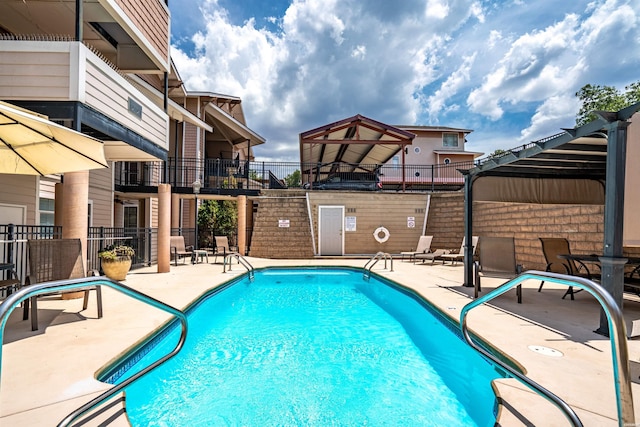 community pool featuring a patio and fence