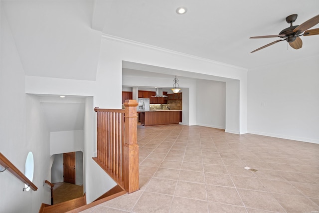 unfurnished living room with light tile patterned floors, stairway, ornamental molding, ceiling fan, and baseboards