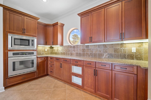 kitchen featuring crown molding, light tile patterned floors, decorative backsplash, appliances with stainless steel finishes, and light stone countertops