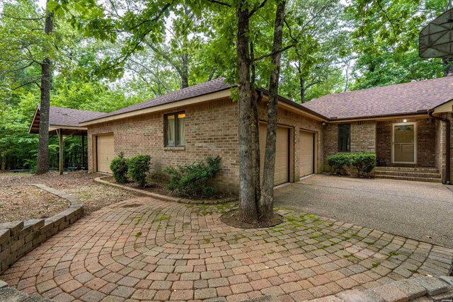 111 Black Oak Ct, Hot Springs, AR 71913 - view of home's exterior with a garage, brick siding, driveway, and a shingled roof