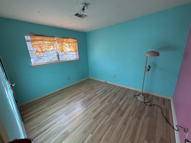 unfurnished bedroom with visible vents, light wood-style flooring, and baseboards