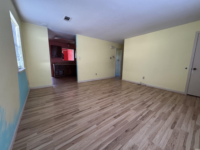 unfurnished living room featuring light wood-type flooring, baseboards, and visible vents