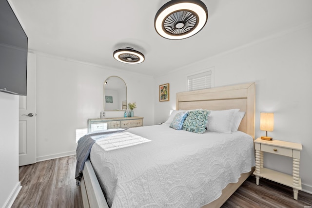 bedroom featuring wood finished floors, baseboards, and ornamental molding