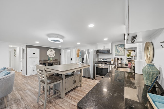 kitchen featuring crown molding, recessed lighting, appliances with stainless steel finishes, light wood-style floors, and a sink