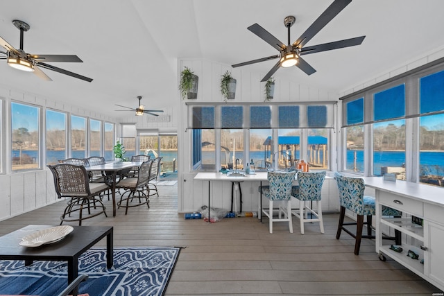 sunroom featuring lofted ceiling, a water view, and ceiling fan