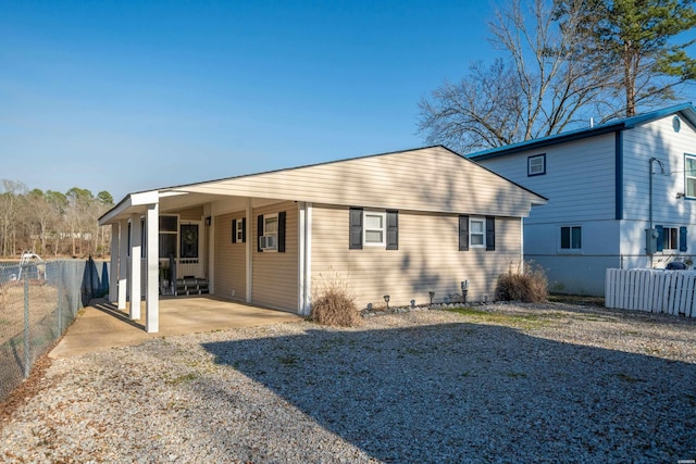 back of house featuring cooling unit, gravel driveway, and fence