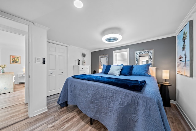 bedroom featuring ornamental molding, baseboards, and wood finished floors