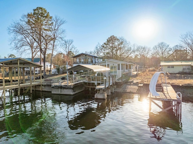 dock area with boat lift, a residential view, and a water view