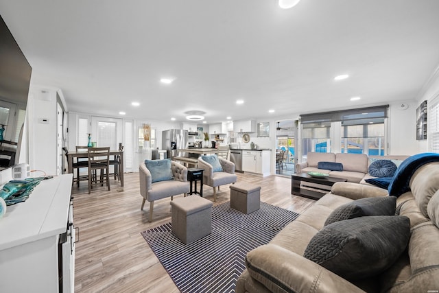 living area with recessed lighting and light wood-style floors