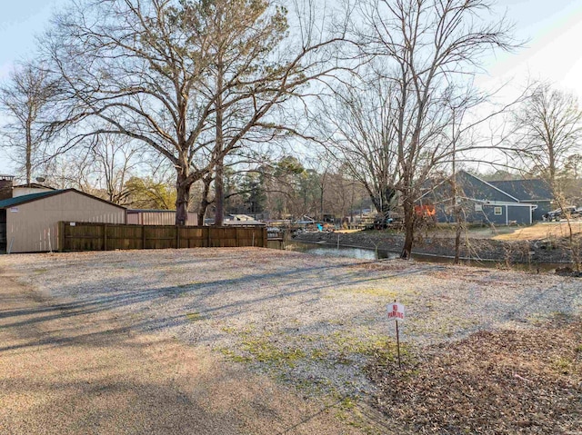 view of yard with an outbuilding, a water view, and a pole building