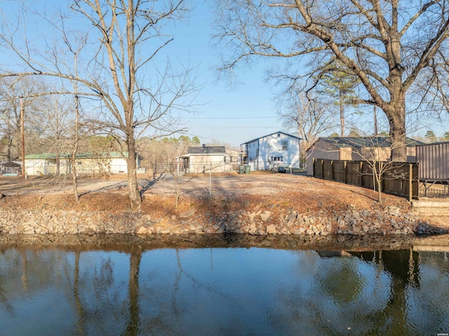 exterior space with a water view and fence