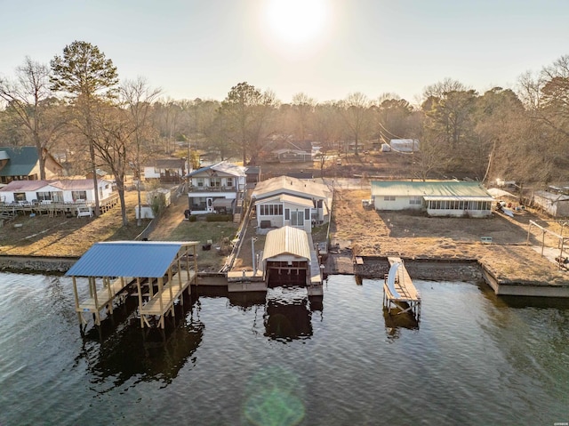 view of dock featuring a water view, a residential view, and boat lift