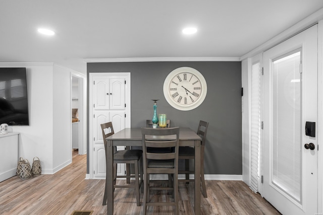 dining area with recessed lighting, baseboards, wood finished floors, and crown molding