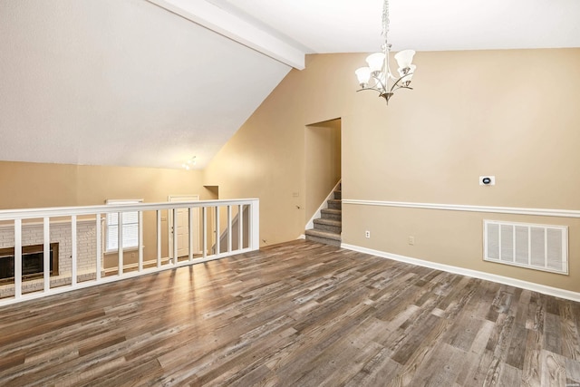 spare room featuring baseboards, visible vents, dark wood-style flooring, vaulted ceiling with beams, and a notable chandelier