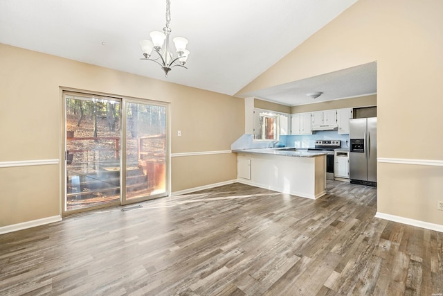 kitchen with under cabinet range hood, stainless steel appliances, a peninsula, white cabinetry, and decorative light fixtures