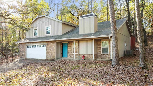 view of front of property with brick siding, roof with shingles, an attached garage, central AC, and driveway