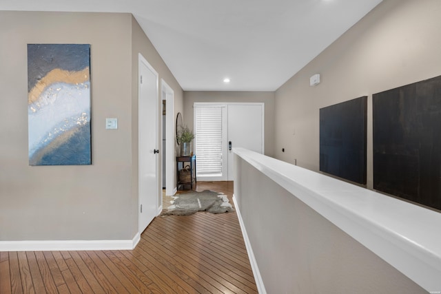 corridor featuring recessed lighting, wood finished floors, and baseboards