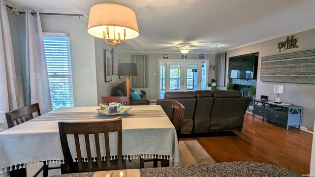 dining room featuring plenty of natural light, a fireplace, ornamental molding, and wood finished floors