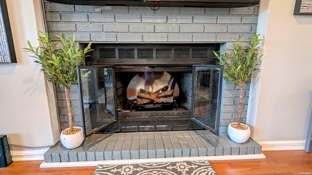 interior details with a fireplace, baseboards, and wood finished floors