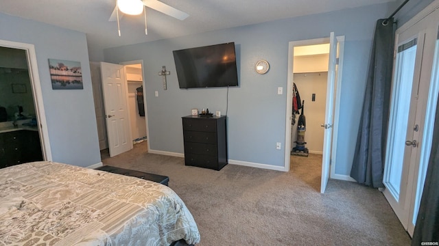 bedroom with light carpet, baseboards, a walk in closet, and a closet