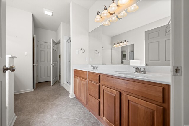 full bathroom featuring a sink, double vanity, a stall shower, and tile patterned flooring