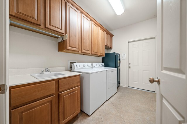 laundry room with light tile patterned floors, cabinet space, a sink, and separate washer and dryer