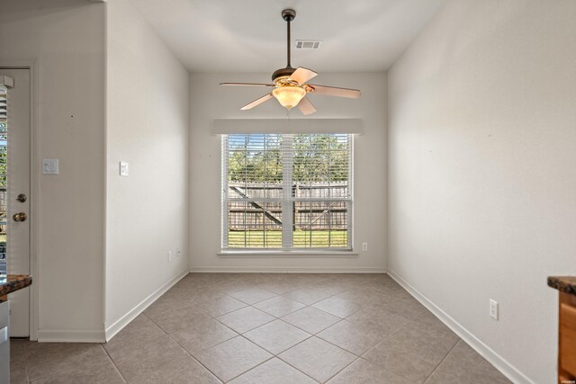 unfurnished dining area with visible vents, ceiling fan, baseboards, and light tile patterned floors