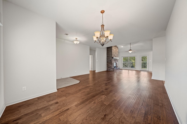 unfurnished living room with ceiling fan with notable chandelier, a fireplace, wood finished floors, visible vents, and baseboards