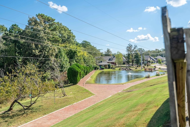 view of swimming pool with a lawn and a water view