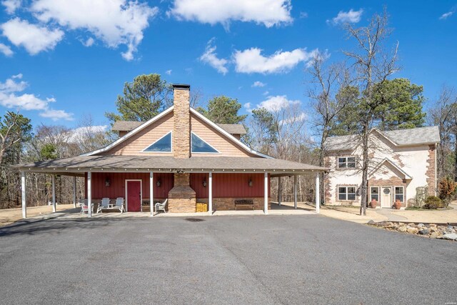 view of front of property with a shingled roof and a chimney