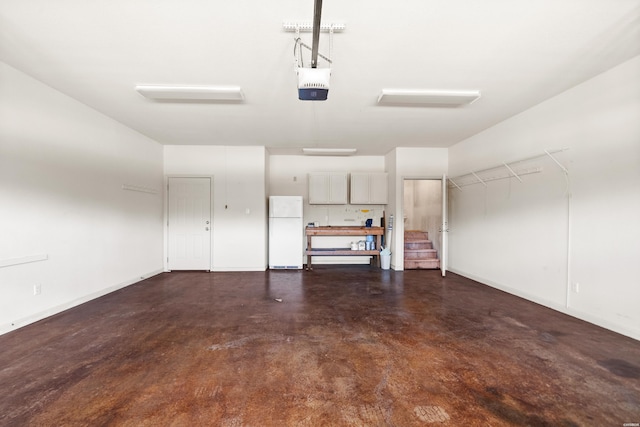 garage with baseboards, a garage door opener, and freestanding refrigerator