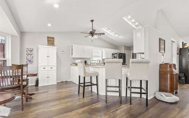 59 Almazan Way, Hot Springs Village, AR 71909 - kitchen featuring lofted ceiling, a peninsula, ceiling fan, white cabinets, and a kitchen breakfast bar