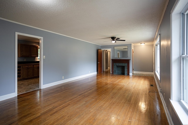301 Riley St, Hot Springs, AR 71901 - unfurnished living room with hardwood / wood-style flooring, ceiling fan, baseboards, a textured ceiling, and crown molding