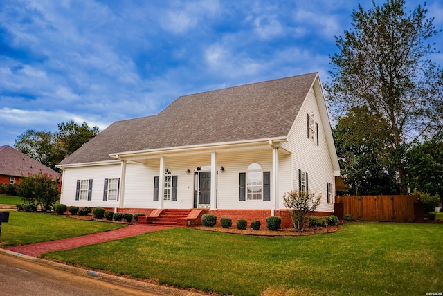 view of front of house featuring a front yard, covered porch, roof with shingles, and fence