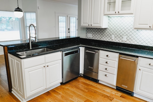 kitchen with a sink, white cabinetry, glass insert cabinets, and stainless steel dishwasher