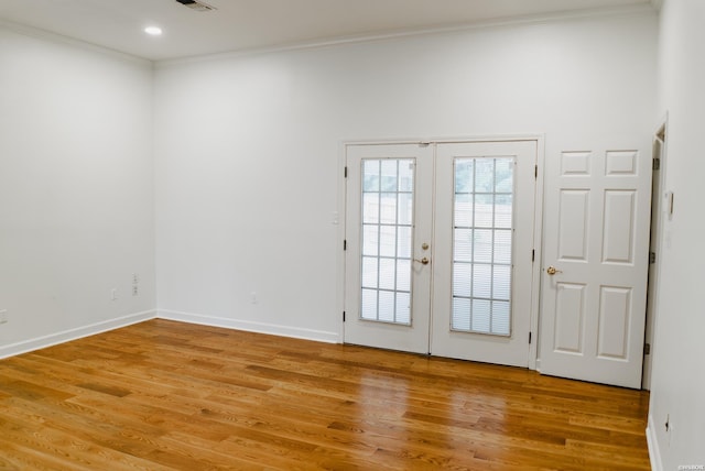 entryway featuring wood finished floors, visible vents, baseboards, ornamental molding, and french doors