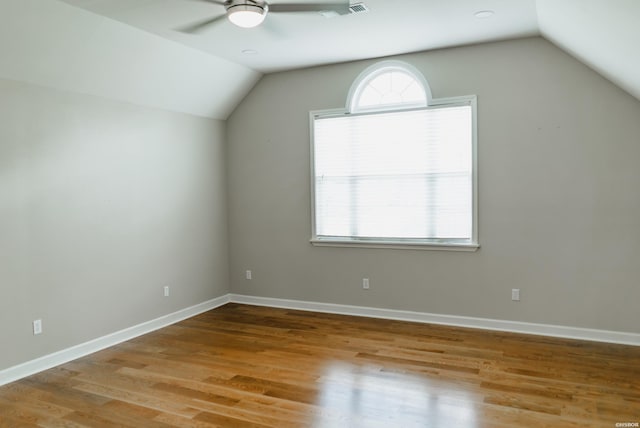 bonus room featuring vaulted ceiling, plenty of natural light, baseboards, and wood finished floors