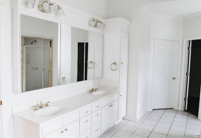 bathroom featuring a shower stall, ornamental molding, a sink, and tile patterned floors