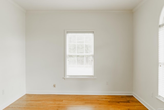 unfurnished room with a healthy amount of sunlight, crown molding, and wood finished floors