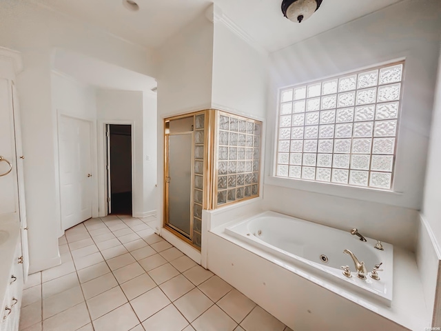 bathroom with a tub with jets, a shower stall, and tile patterned floors