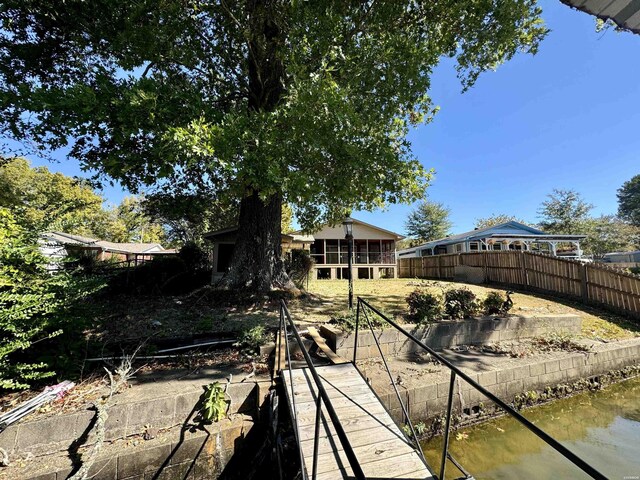 exterior space featuring a water view and fence