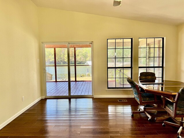 interior space featuring lofted ceiling, dark wood-style flooring, visible vents, and baseboards