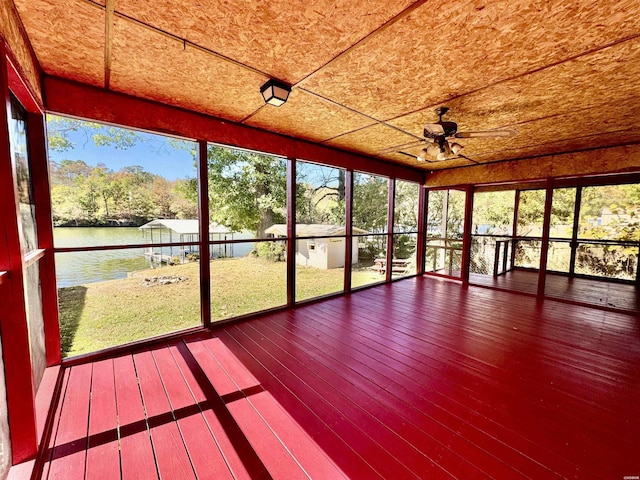 unfurnished sunroom featuring a water view and a ceiling fan