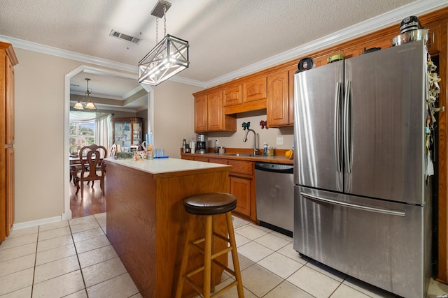 103 Deer View Ct, Hot Springs, AR 71913 - kitchen featuring appliances with stainless steel finishes, a sink, a center island, light tile patterned floors, and ornamental molding