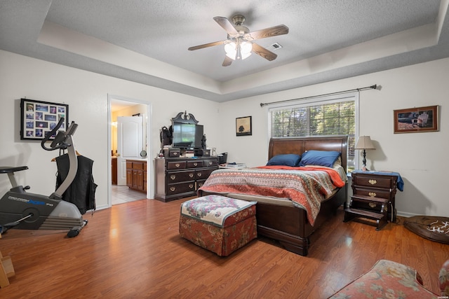 103 Deer View Ct, Hot Springs, AR 71913 - bedroom with wood finished floors, a raised ceiling, baseboards, a textured ceiling, and connected bathroom