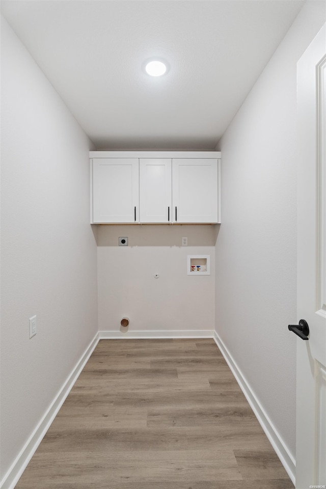 laundry room featuring hookup for an electric dryer, washer hookup, baseboards, light wood-type flooring, and cabinet space