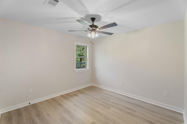 empty room featuring light wood-type flooring, visible vents, ceiling fan, and baseboards