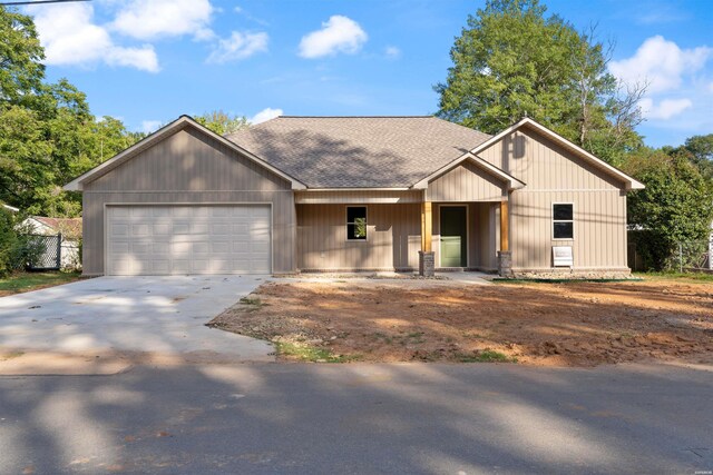 view of front of house featuring driveway, a shingled roof, fence, and an attached garage