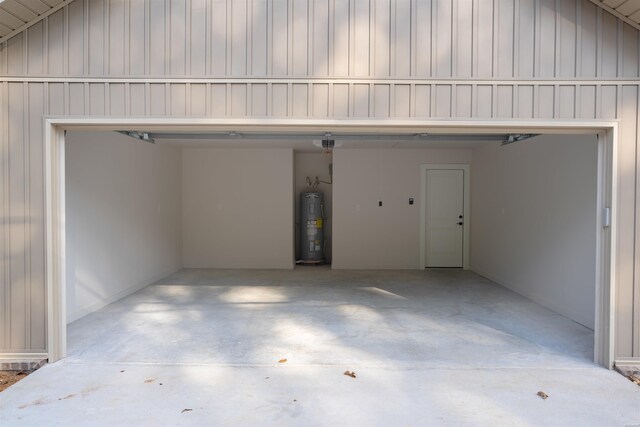 garage with a garage door opener, concrete driveway, and electric water heater