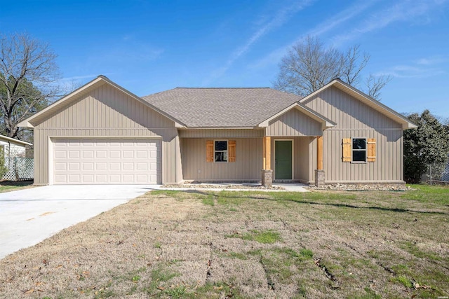 view of front of property featuring a front yard, concrete driveway, roof with shingles, and an attached garage